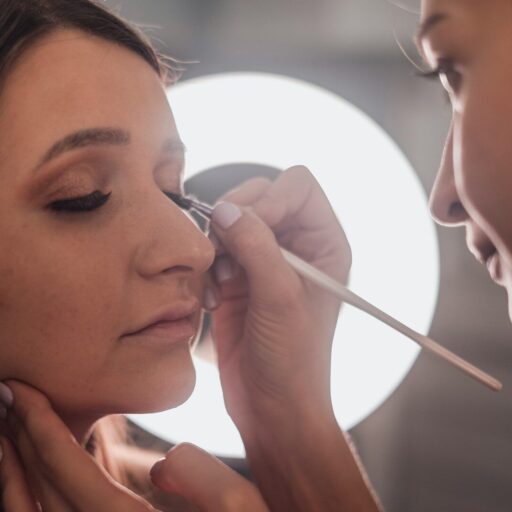 woman putting eyeliner on another woman's eye